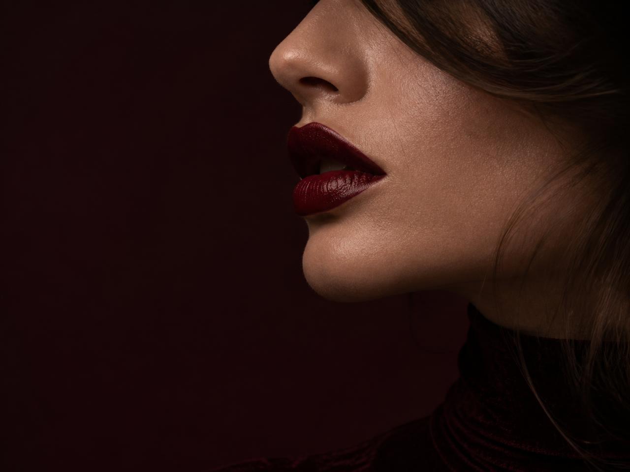 Editorial beauty detail of a profile with deep cherry lip color
